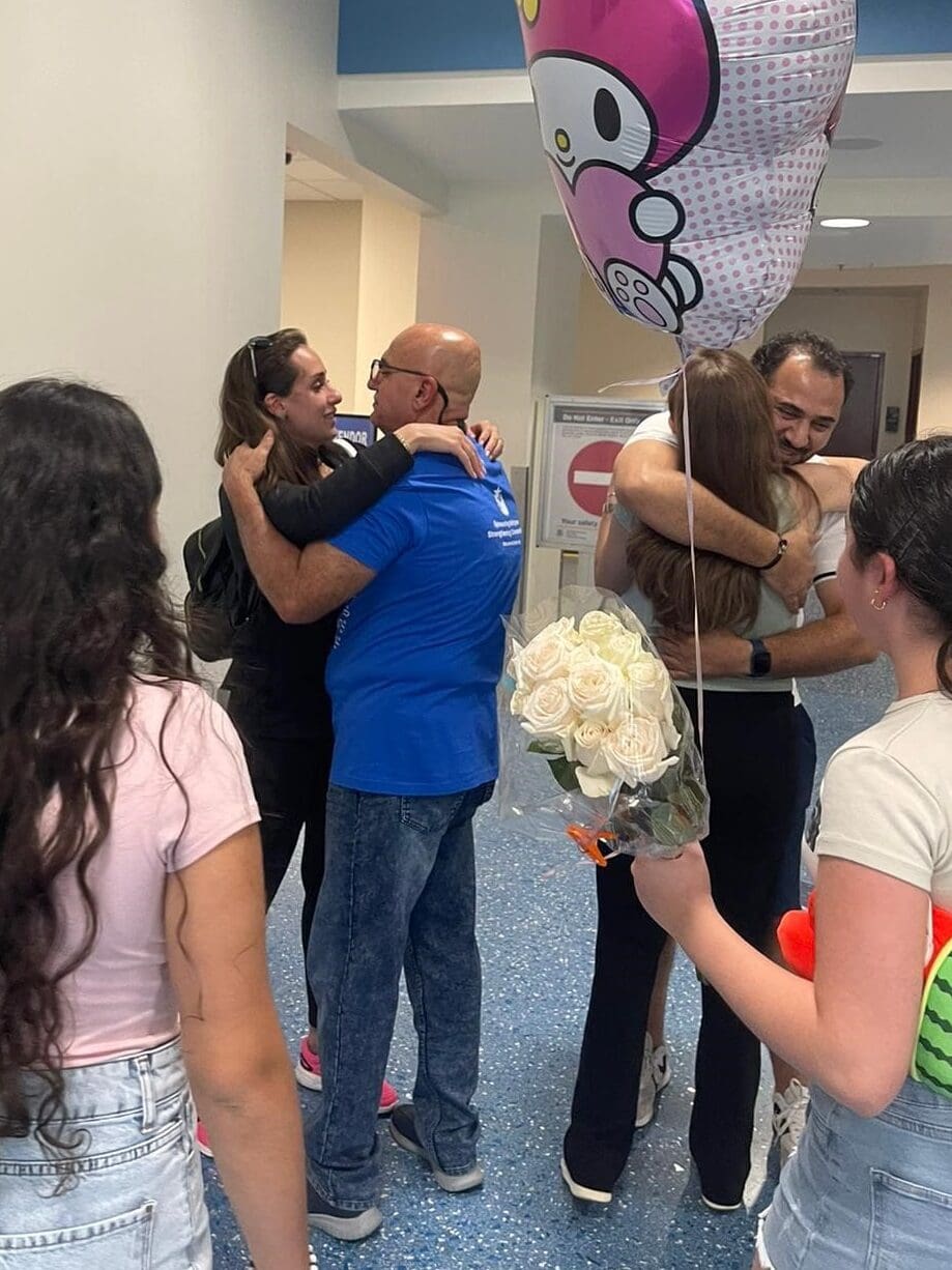 Enji hugging her father, Muntasser, for the first time in more than 9 years at the airport in the United State